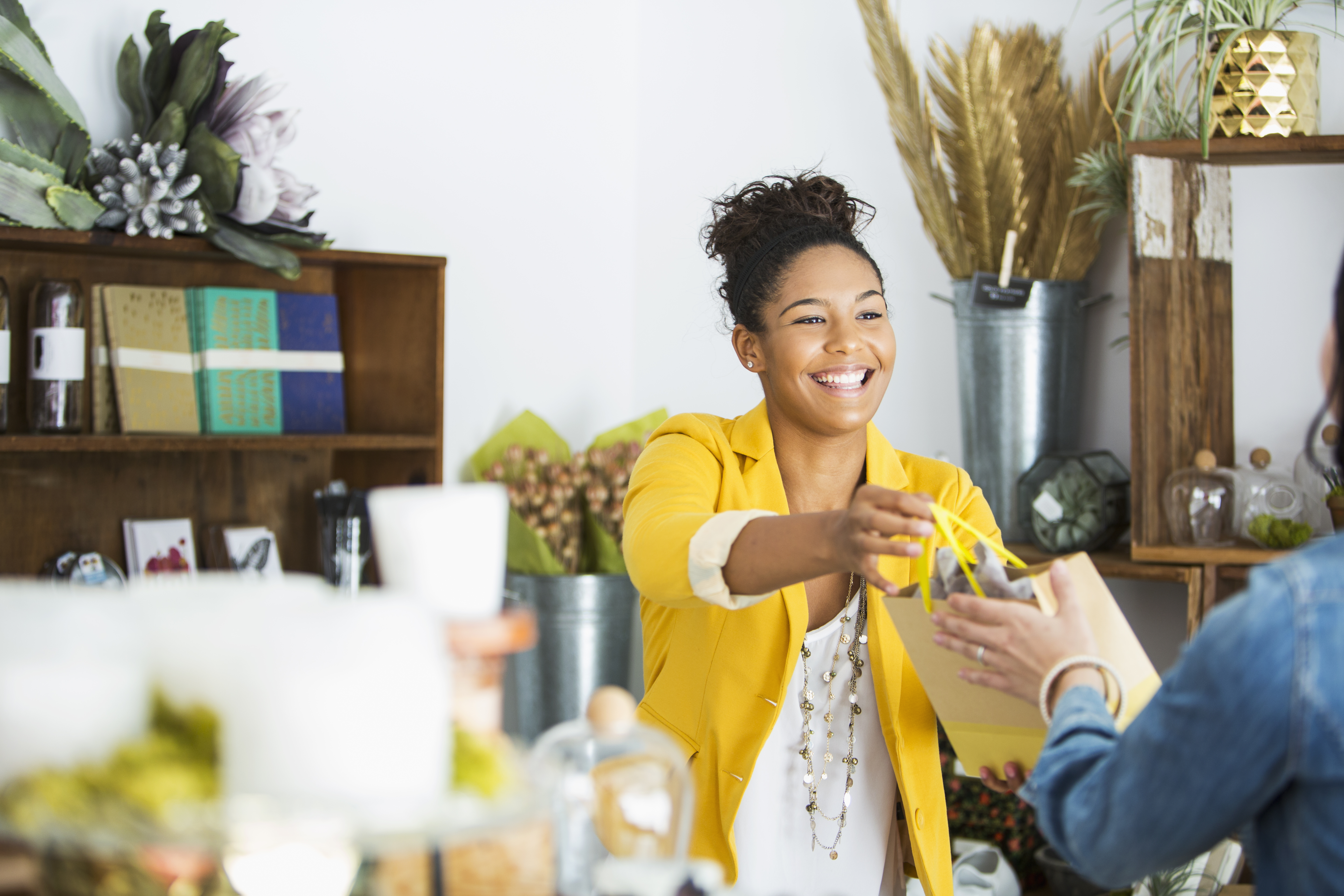 Woman handing a purchased item to a customer